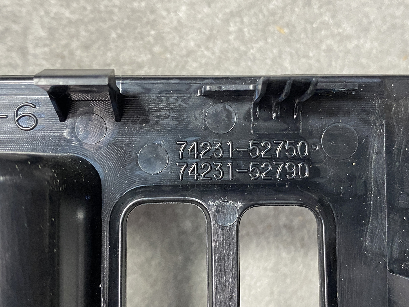 14021815_pw_switch_10 TOYOTA Genuine Master Power Window Switch AQUA NHP10 / 192830 / 74231-52750 / 74231-52790 » NZ4.95 » JDM-PARTS NZ » JDM-PARTS NZ Close-up of a black plastic automotive component with embossed part numbers 74231-52750 and 74231-52790, showing small tabs and ridges. TOYOTA Genuine Master Power Window Switch AQUA NHP10 / 192830 / 74231-52750 / 74231-52790 » JDM-PARTS NZ