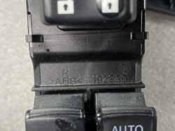 Close-up of a black car switch with an 'AUTO' button; the housing is stamped with 'R ABS 192830'.