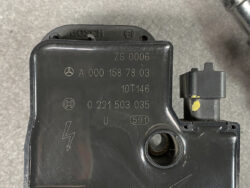 Automotive electronic control module (Mercedes) with part numbers and logos visible on a black plastic housing