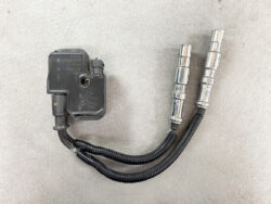 Automotive ignition coil with twin spark plug cables on a gray surface. Mercedes-Benz Genuine IGNITION COIL Pack / A0001587803 / M112, M113 Engine  #3 #4 » JDM-PARTS NZ