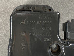 Black automotive electrical control module with Bosch logo and multiple part numbers (e.g., A 000 158 78 03, 0 221 503 035) and a warning lightning bolt symbol on the case.