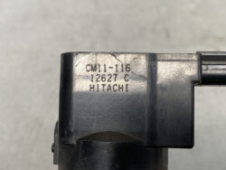 Close-up of a black plastic component with stamped model text 'CM11-16 12627 C HITACHI'.
