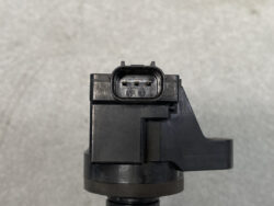 Close-up of a black plastic electrical connector with four metal pins on a device component