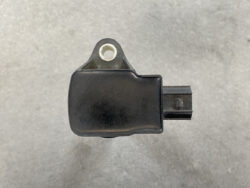 Black automotive sensor with a mounting tab and side electrical connector, used for engine/vehicle systems.