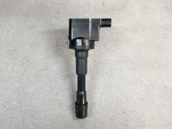 Ignition coil with rubber boot and connector, car engine part on a gray surface