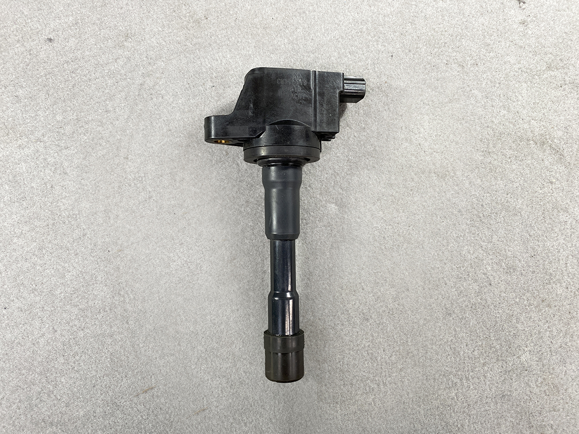 HON-COIL-CM11-119_4 HONDA Genuine IGNITION COIL CM11-119 / L-series Engine » NZ.95 » JDM-PARTS NZ » JDM-PARTS NZ Vehicle ignition coil with connector on top and rubber boot at bottom on a gray surface. HONDA Genuine IGNITION COIL CM11-119 / L-series Engine » JDM-PARTS NZ