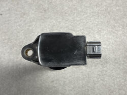 Automotive sensor module with a mounting hole and a two-pin electrical connector against a gray surface.