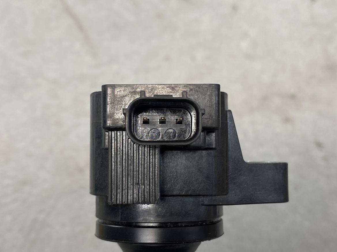 HON-COIL-CM11-121A_3 HONDA Genuine IGNITION COIL CM11-121A / L-series Engine » NZ.95 » JDM-PARTS NZ » JDM-PARTS NZ Close-up of a three-pin rectangular electrical connector embedded in a black plastic device. HONDA Genuine IGNITION COIL CM11-121A / L-series Engine » JDM-PARTS NZ
