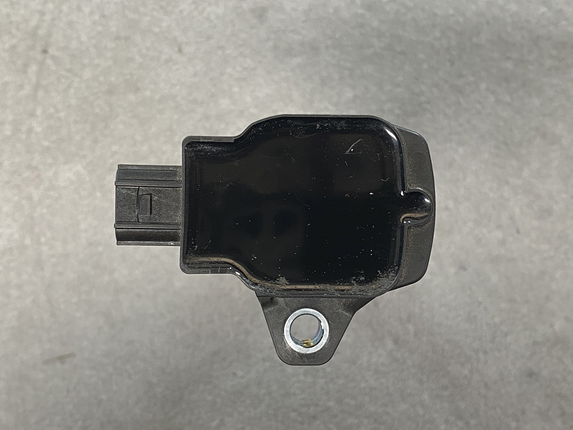 HON-COIL-CM11-121A_6 HONDA Genuine IGNITION COIL CM11-121A / L-series Engine » NZ.95 » JDM-PARTS NZ » JDM-PARTS NZ Small black automotive sensor with a mounting tab and left-side electrical connector. HONDA Genuine IGNITION COIL CM11-121A / L-series Engine » JDM-PARTS NZ