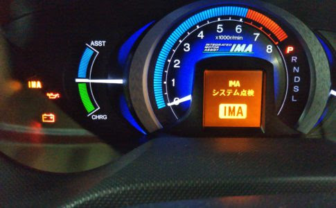 Close-up of a car dashboard with a blue RPM gauge and an orange IMA system check screen displaying 'IMA'. Vehicle Diagnostics & Error Code Reset Services in Christchurc » JDM-PARTS NZ