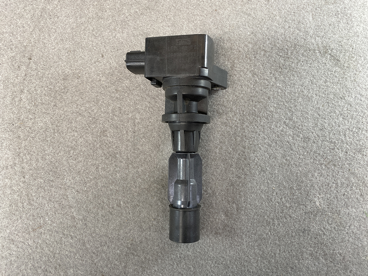 MAZ-COIL-LF2L_4 MAZDA Genuine IGNITION COIL K4238 / LF2L-18-100 / LF, L3 Engine » NZ.95 » JDM-PARTS NZ » JDM-PARTS NZ Ignition coil with electrical connector, resting on a gray surface (coil-on-plug style). MAZDA Genuine IGNITION COIL K4238 / LF2L-18-100 / LF, L3 Engine » JDM-PARTS NZ