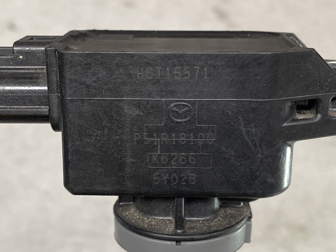 MAZ-COIL-P51R18100_2 MAZDA Genuine IGNITION COIL H6T15571 / P51R-18-100 SKYACTIV-G » NZ.95 » JDM-PARTS NZ » JDM-PARTS NZ Close-up of a black Mazda automotive module with embossed diagram and serial numbers on its surface. MAZDA Genuine IGNITION COIL H6T15571 / P51R-18-100 SKYACTIV-G » JDM-PARTS NZ