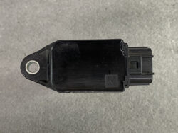 Black plastic automotive sensor/module with a mounting hole on the left and a multi-pin connector on the right.