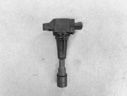 Automotive ignition coil pack with attached spark plug boot on a gray background