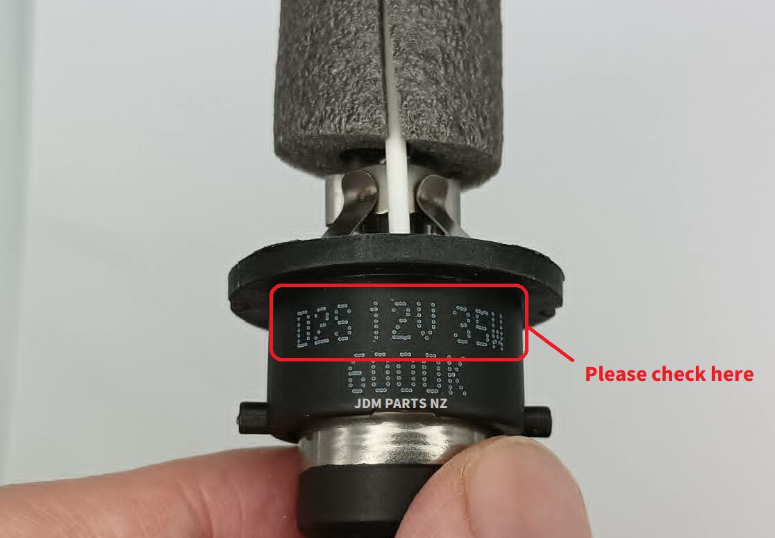 NEW Headlight Bulbs D2R D2S Xenon HID 6000K-1 SUZUKI NEW Headlight Bulbs D2R D2S Xenon HID 6000K x2 (1 Pair) » NZ.95 » JDM-PARTS NZ » JDM-PARTS NZ Close-up of a black automotive sensor showing a dotted serial number on a label, being inspected by a fingered hand. SUZUKI NEW Headlight Bulbs D2R D2S Xenon HID 6000K x2 (1 Pair) » JDM-PARTS NZ