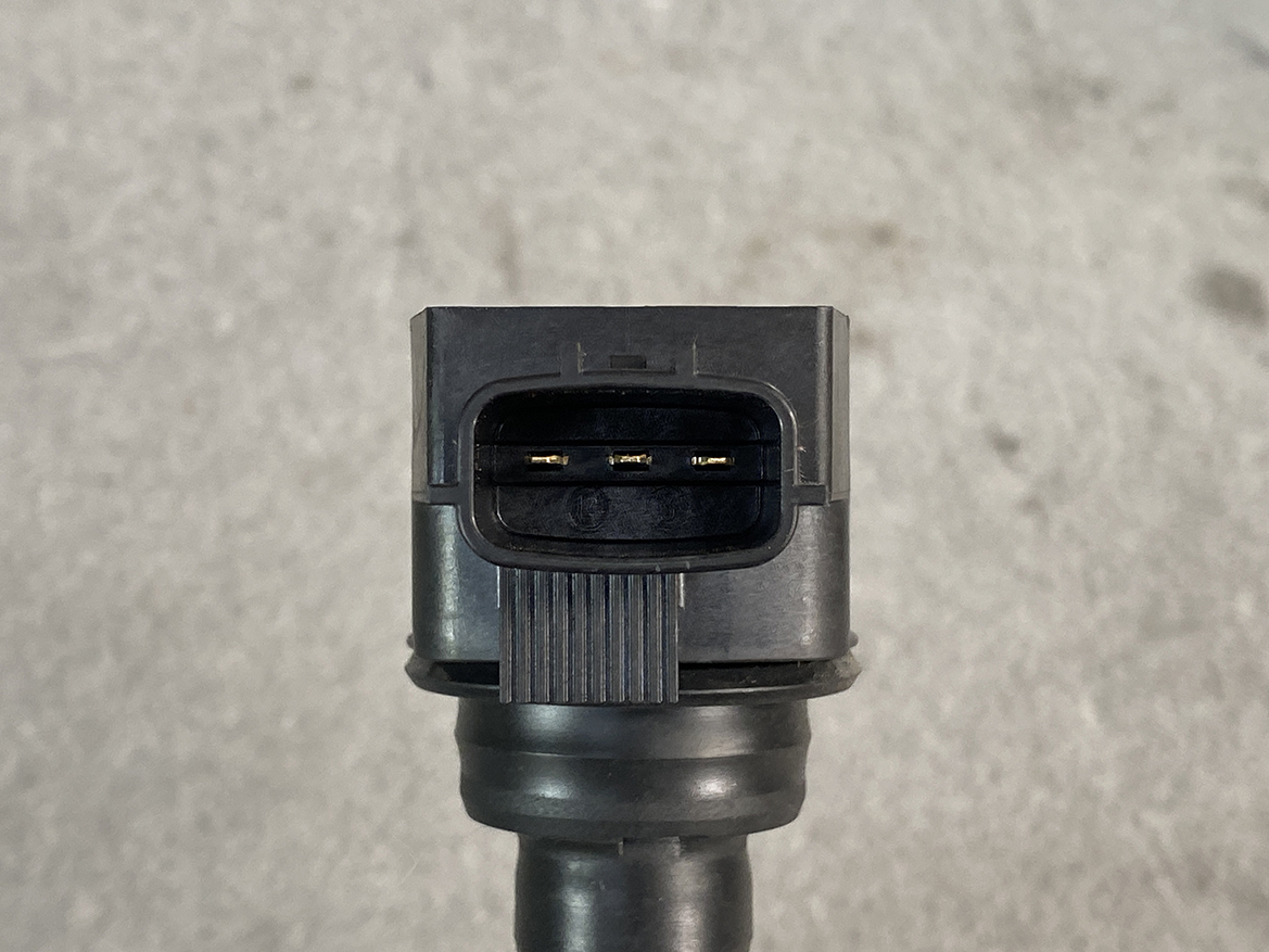 NIS-COIL-1KT0A_3 NISSAN Genuine Ignition Coil 22448 1KT0A / HR, MR, QR Engine » NZ.95 » JDM-PARTS NZ » JDM-PARTS NZ Close-up of a black three-pin automotive electrical connector with gold pins on a cable. NISSAN Genuine Ignition Coil 22448 1KT0A / HR, MR, QR Engine » JDM-PARTS NZ