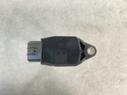 Black automotive sensor with rectangular body, plug on the left, and a mounting tab with a hole on the right.