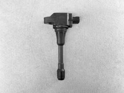 Automotive ignition coil with a rubber boot on a gray textured surface