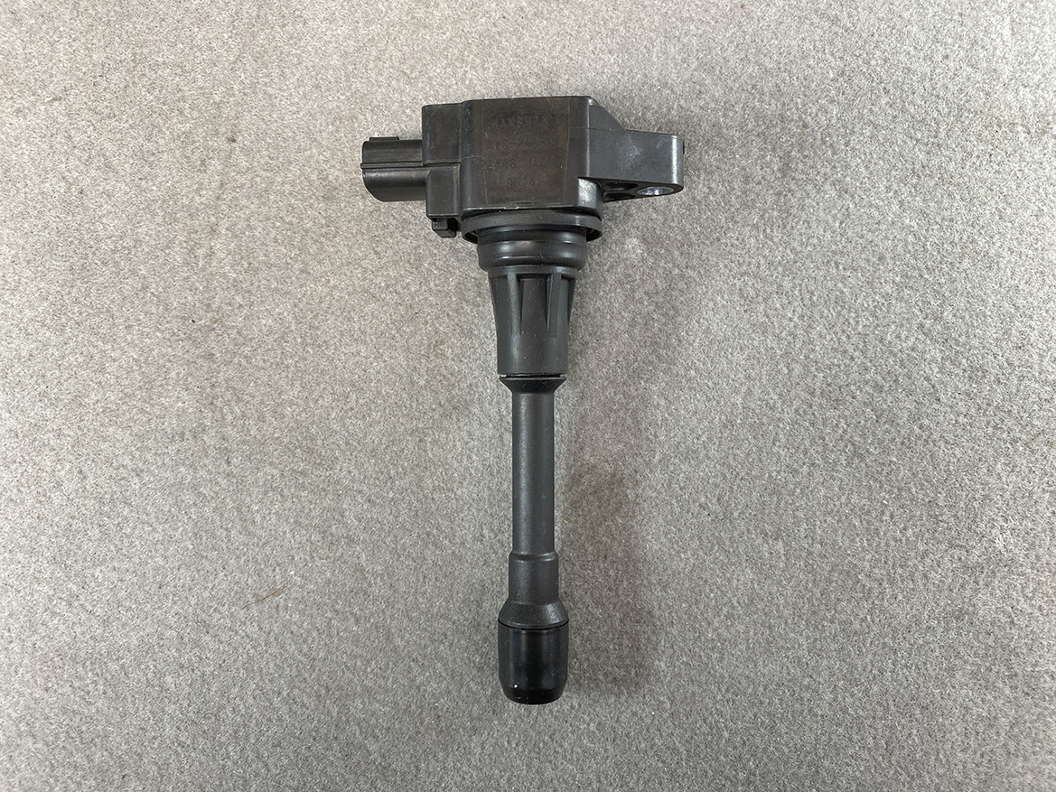 NIS-COIL-JA00C_4 NISSAN Genuine IGNITION COIL 22448 JA00C / MR QR Engine » NZ.95 » JDM-PARTS NZ » JDM-PARTS NZ Ignition coil with rubber boot and electrical connector on a gray surface (auto part) NISSAN Genuine IGNITION COIL 22448 JA00C / MR QR Engine » JDM-PARTS NZ