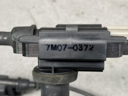 Close-up of a black metal clamp with the stamped serial 7M07-0372 on a mounting rail.