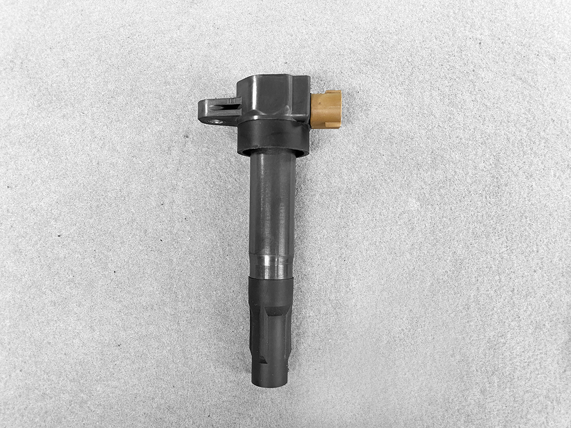 SUZ-COIL-DL3_1 SUZUKI Genuine IGNITION COIL / DL3 / 3731 / K12B, K6A, R06A Engine » NZ.95 » JDM-PARTS NZ » JDM-PARTS NZ Ignition coil with a brown electrical connector on top, placed on a gray surface. SUZUKI Genuine IGNITION COIL / DL3 / 3731 / K12B, K6A, R06A Engine » JDM-PARTS NZ