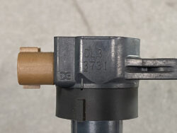 Close-up of a metal valve component with an orange plastic cap and a long lever, stamped DL3 3731.
