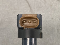 Close-up of a brown, 3-pin automotive electrical connector on a sensor housing.