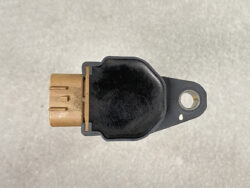 Close-up of a black automotive sensor with a tan 3-pin connector on the left and a mounting tab on the right