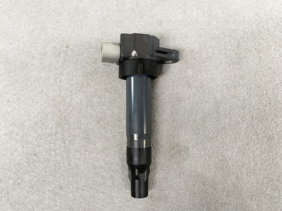 SUZ-COIL-DL4_4 SUZUKI Genuine IGNITION COIL / DL4 / 5309 / R06A Engine » NZ.95 » JDM-PARTS NZ » JDM-PARTS NZ Automotive ignition coil with a grey metal body and black plastic top, including a mounting tab and electrical connector SUZUKI Genuine IGNITION COIL / DL4 / 5309 / R06A Engine » JDM-PARTS NZ