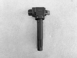 Automotive ignition coil with electrical connector, shown on a gray background, part of the ignition system.