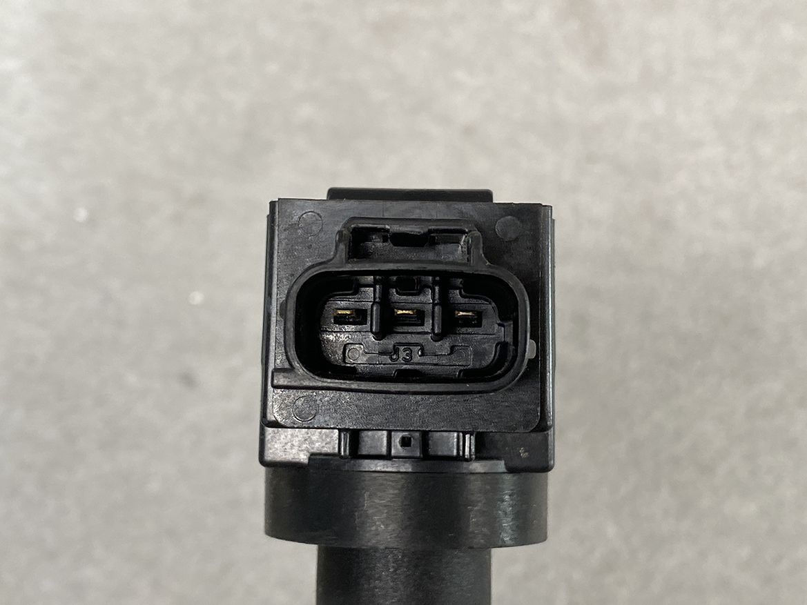 SUZ-COIL-FK0508_3 SUZUKI Genuine IGNITION COIL FK0508 / R06A, K12B Engine » NZ.95 » JDM-PARTS NZ » JDM-PARTS NZ Close-up of a black, three-pin automotive electrical connector with visible gold contacts on a gray background edge of a cable starter. SUZUKI Genuine IGNITION COIL FK0508 / R06A, K12B Engine » JDM-PARTS NZ
