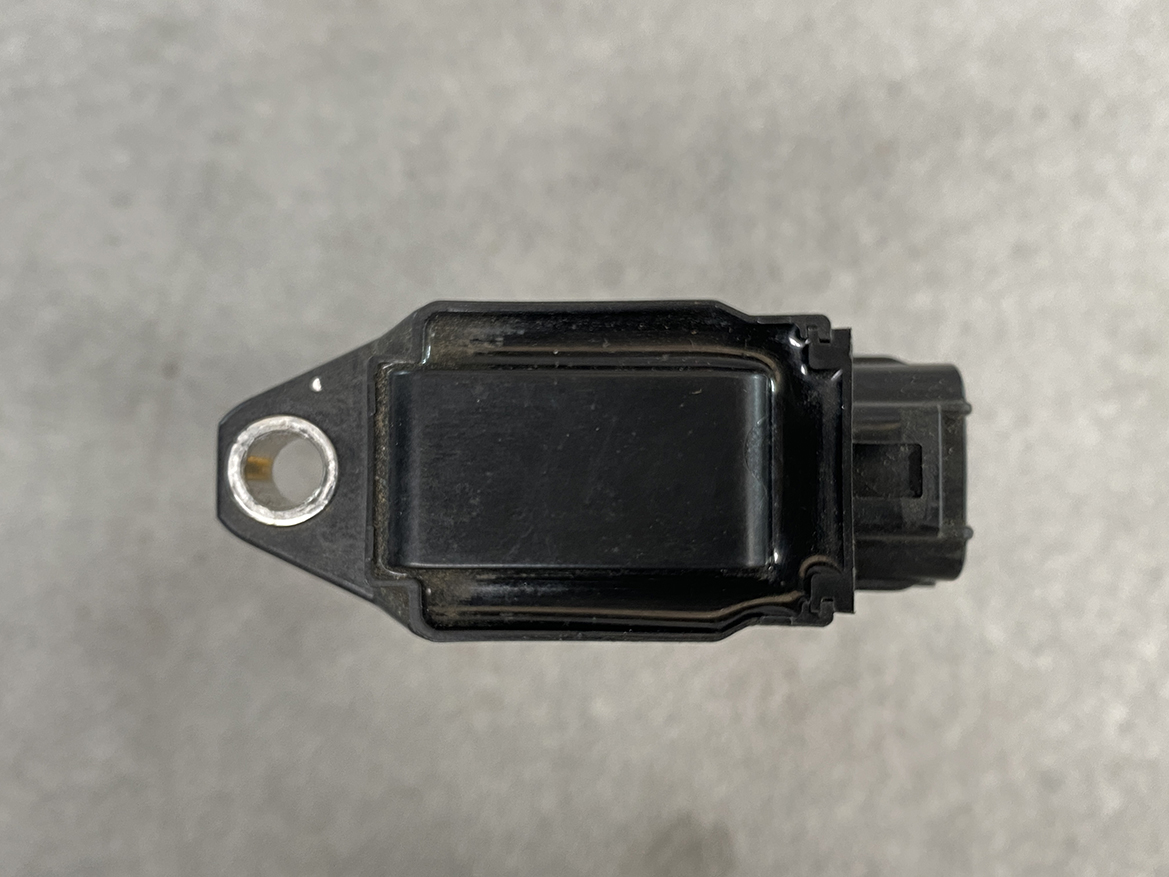 SUZ-COIL-FK0508_6 SUZUKI Genuine IGNITION COIL FK0508 / R06A, K12B Engine » NZ.95 » JDM-PARTS NZ » JDM-PARTS NZ Top view of a black rectangular automotive sensor with a mounting hole on the left and a right-side electrical connector. SUZUKI Genuine IGNITION COIL FK0508 / R06A, K12B Engine » JDM-PARTS NZ