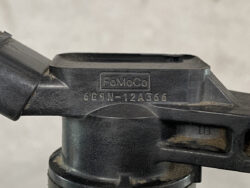 Close-up of a FoMoCo tripod head with the engraved serial 6G9N-12A366 on the side, black plastic/metal finish