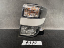 Tail light assembly for a vehicle featuring amber turn signal and clear reverse lights, shown on a dark surface.