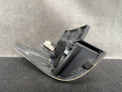 Detached automotive interior trim piece with wiring harness and white connector, likely a dashboard switch panel or control module.