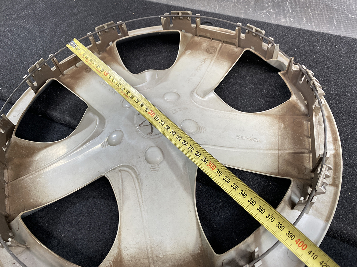 B391_5 TOYOTA RACTIS NSP120, NCP120 Genuine 16inch WHEEL CAP / HUB CAP 42602-52460 » NZ.95 » JDM-PARTS NZ » JDM-PARTS NZ Circular beige plastic car wheel cover with a tape measure laid diagonally across it, showing a diameter of about 38 cm (roughly 15 inches). TOYOTA RACTIS NSP120, NCP120 Genuine 16inch WHEEL CAP / HUB CAP 42602-52460 » JDM-PARTS NZ
