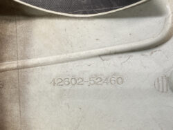 Close-up of a dusty metal surface with the engraved part number 42602-52460 and a circular indent to the right.