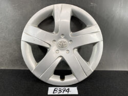 Silver Toyota hubcap with five-spoke design and central logo, showing surface scuffs and light wear