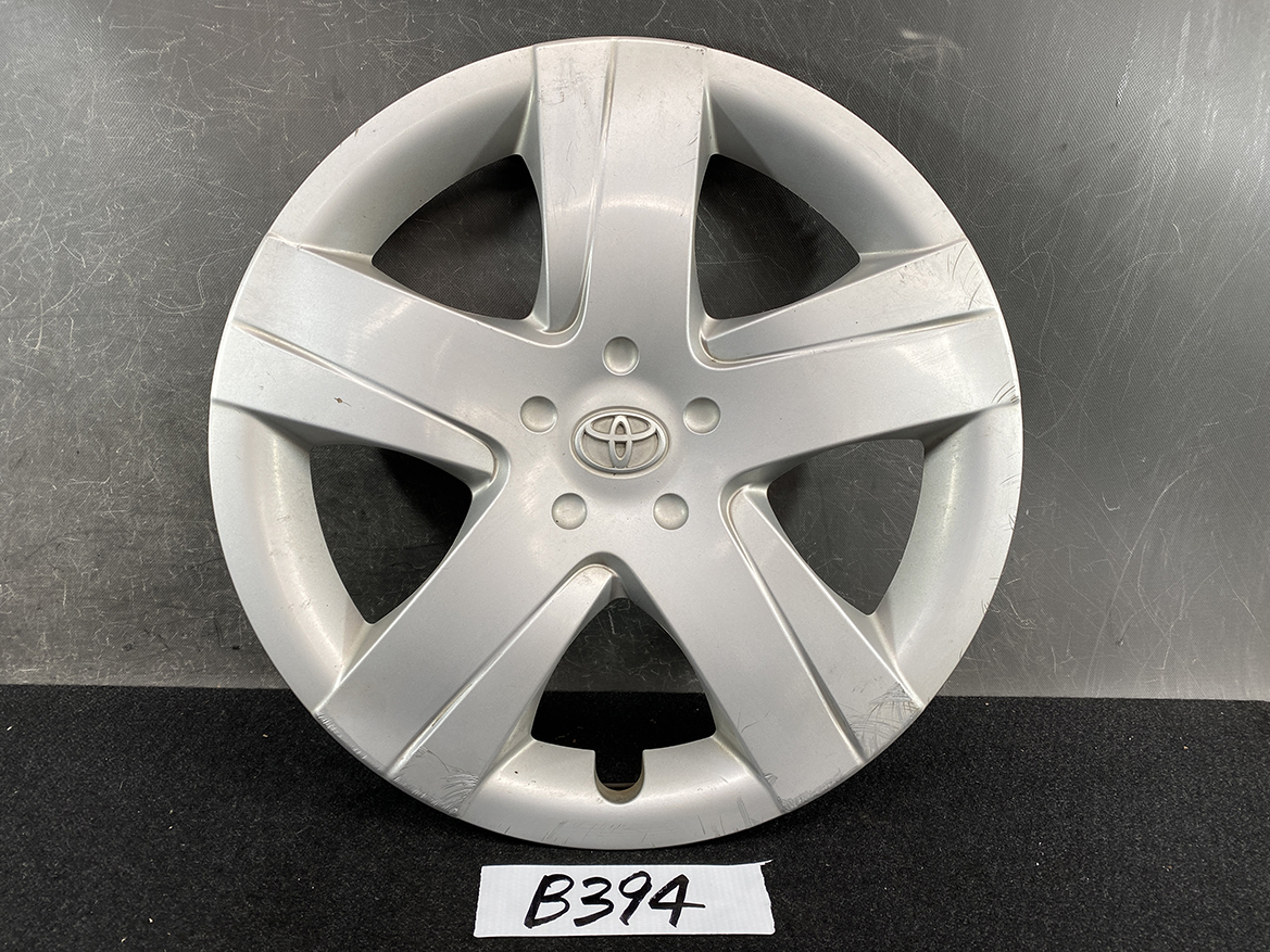 B394_1 TOYOTA RACTIS NSP120, NCP120 Genuine 16inch WHEEL CAP / HUB CAP 42602-52460 » NZ.95 » JDM-PARTS NZ » JDM-PARTS NZ Silver Toyota hubcap with five-spoke design and central logo, showing surface scuffs and light wear TOYOTA RACTIS NSP120, NCP120 Genuine 16inch WHEEL CAP / HUB CAP 42602-52460 » JDM-PARTS NZ