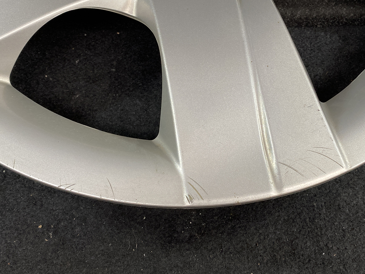 B394_7 TOYOTA RACTIS NSP120, NCP120 Genuine 16inch WHEEL CAP / HUB CAP 42602-52460 » NZ.95 » JDM-PARTS NZ » JDM-PARTS NZ Close-up of a silver alloy wheel rim with several scratches along the outer lip against a dark background TOYOTA RACTIS NSP120, NCP120 Genuine 16inch WHEEL CAP / HUB CAP 42602-52460 » JDM-PARTS NZ