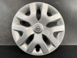 Silver Nissan wheel hubcap with several scratches and a central Nissan emblem