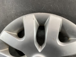 Close-up of a silver alloy wheel with visible scratches and scuffs on the surface.