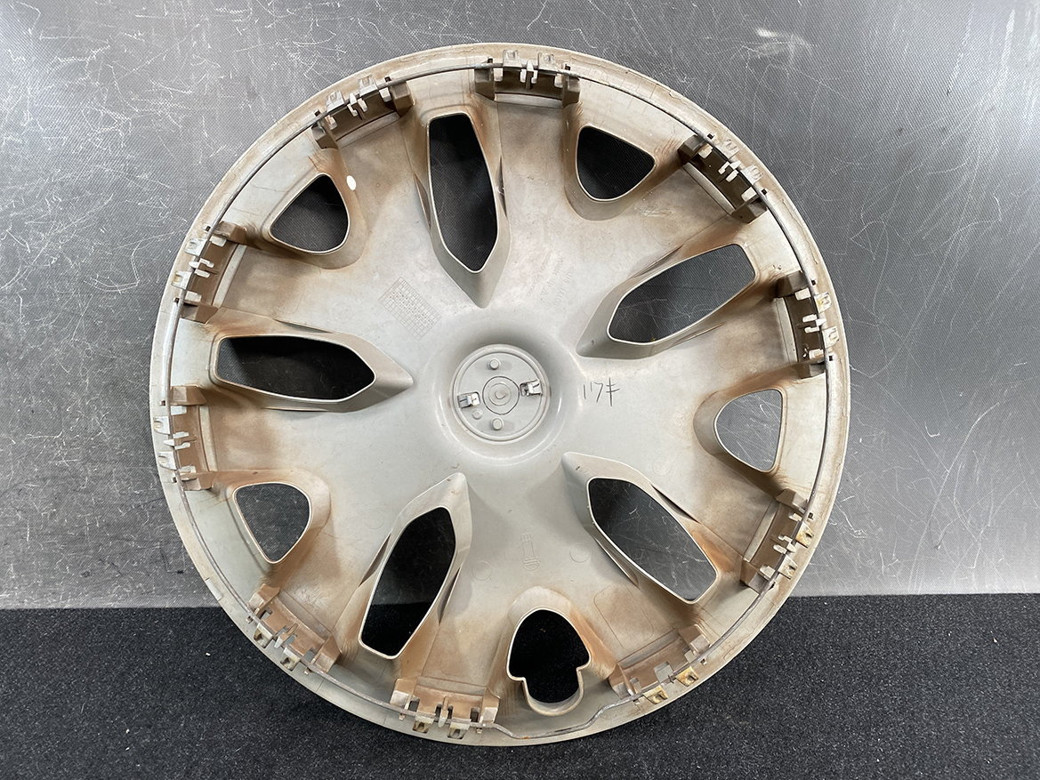 B399_3 NISSAN LEAF AZE0 Genuine 16inch WHEEL CAP / HUB CAP 40315 1KL0B x1 » NZ.95 » JDM-PARTS NZ » JDM-PARTS NZ Circular car wheel hubcap with multiple curved spokes, dusty brown staining, resting on a dark surface NISSAN LEAF AZE0 Genuine 16inch WHEEL CAP / HUB CAP 40315 1KL0B x1 » JDM-PARTS NZ