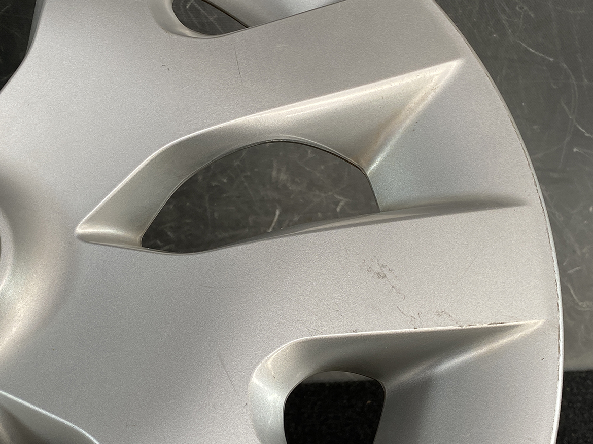B399_5 NISSAN LEAF AZE0 Genuine 16inch WHEEL CAP / HUB CAP 40315 1KL0B x1 » NZ.95 » JDM-PARTS NZ » JDM-PARTS NZ Close-up of a silver alloy wheel with scratches and scuff marks on the rim NISSAN LEAF AZE0 Genuine 16inch WHEEL CAP / HUB CAP 40315 1KL0B x1 » JDM-PARTS NZ