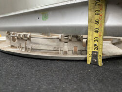 Close-up of a yellow tape measure extended vertically beside a circular gray metal rim on a dark surface, showing about 60 cm in height for scale.