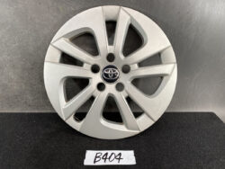 Silver alloy wheel with Toyota emblem at center and a multi-spoke design, placed on a dark surface.
