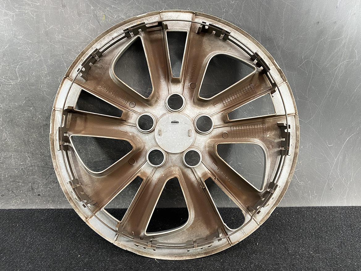 B405_3 TOYOTA PRIUS ZVW50 ZVW51 Genuine 15inch WHEEL CAP / HUB CAP » NZ.95 » JDM-PARTS NZ » JDM-PARTS NZ Brown alloy car wheel rim with multiple spokes lying on a dark surface, center hub visible, dusty and used-looking. TOYOTA PRIUS ZVW50 ZVW51 Genuine 15inch WHEEL CAP / HUB CAP » JDM-PARTS NZ