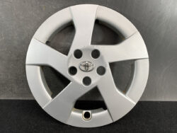 Silver Toyota hubcap with five spokes and a central Toyota emblem; shows lug nut holes around the center.