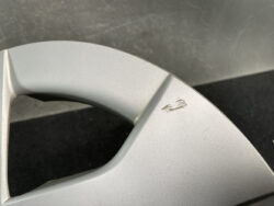 Close-up of a silver alloy wheel with a small scratch near the spoke.