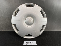 Silver Toyota hubcap with centered logo, shown from the front on a dark surface.